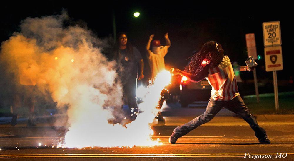 [Guy in an American flag T-shirt throwing a smoke bomb while holding a bag of chips]